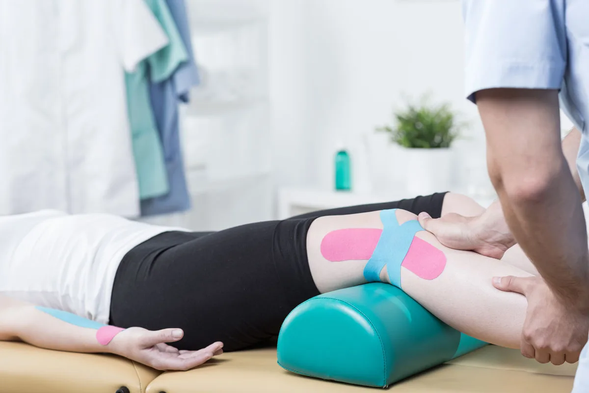 Therapeutic taping on a patient’s leg